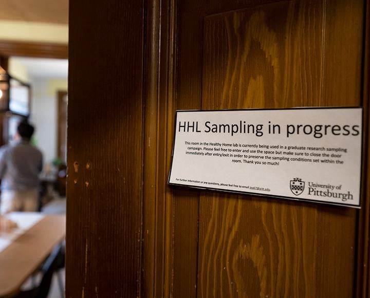 A sign on a wooden door reads HHL Sampling in progress