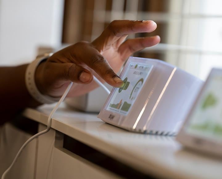 A hand presses the touchscreen on a smart device