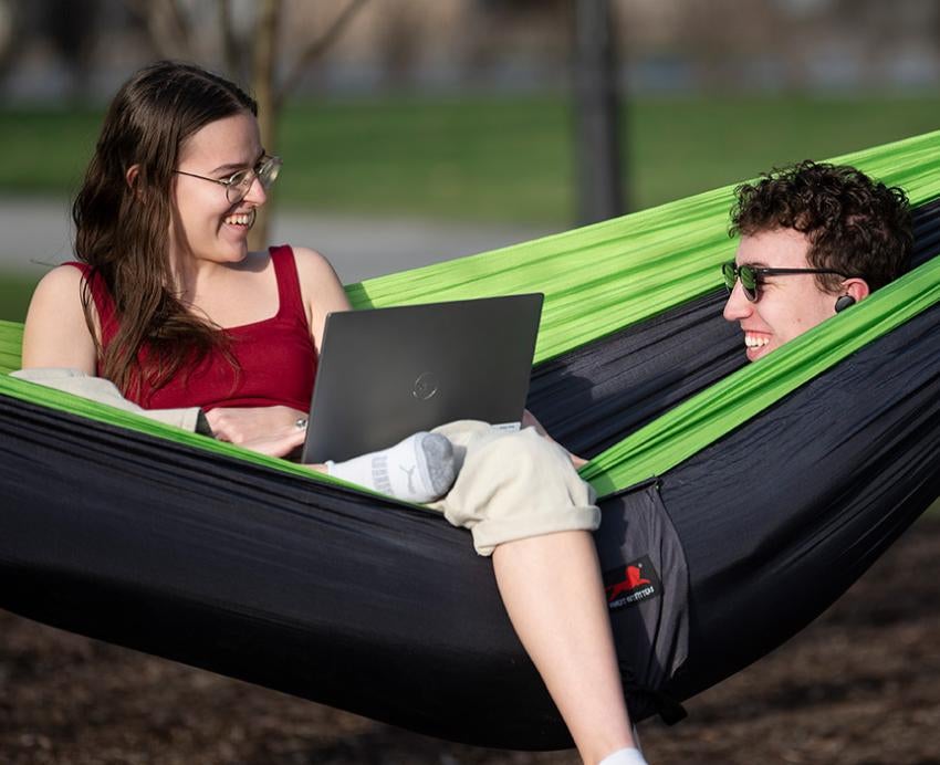 Two students sit in a hammock