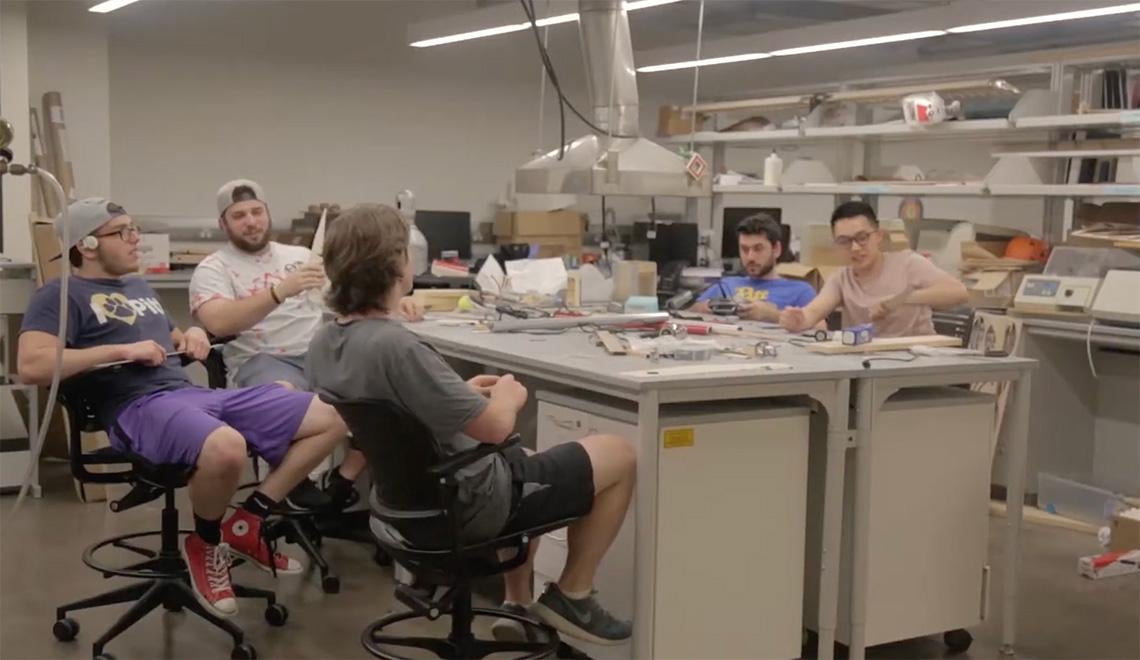 Students sit around a table in a lab