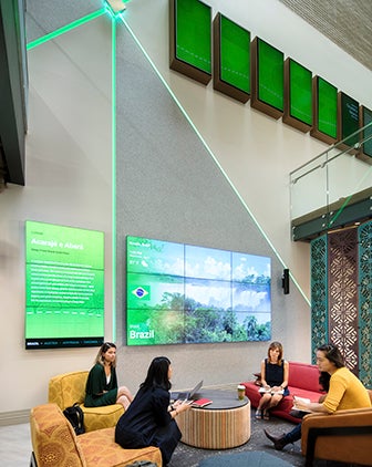 Two-floor image of Global Hub, showing students sitting in the lower floor with a giant Experience Screen showing images of Brazil
