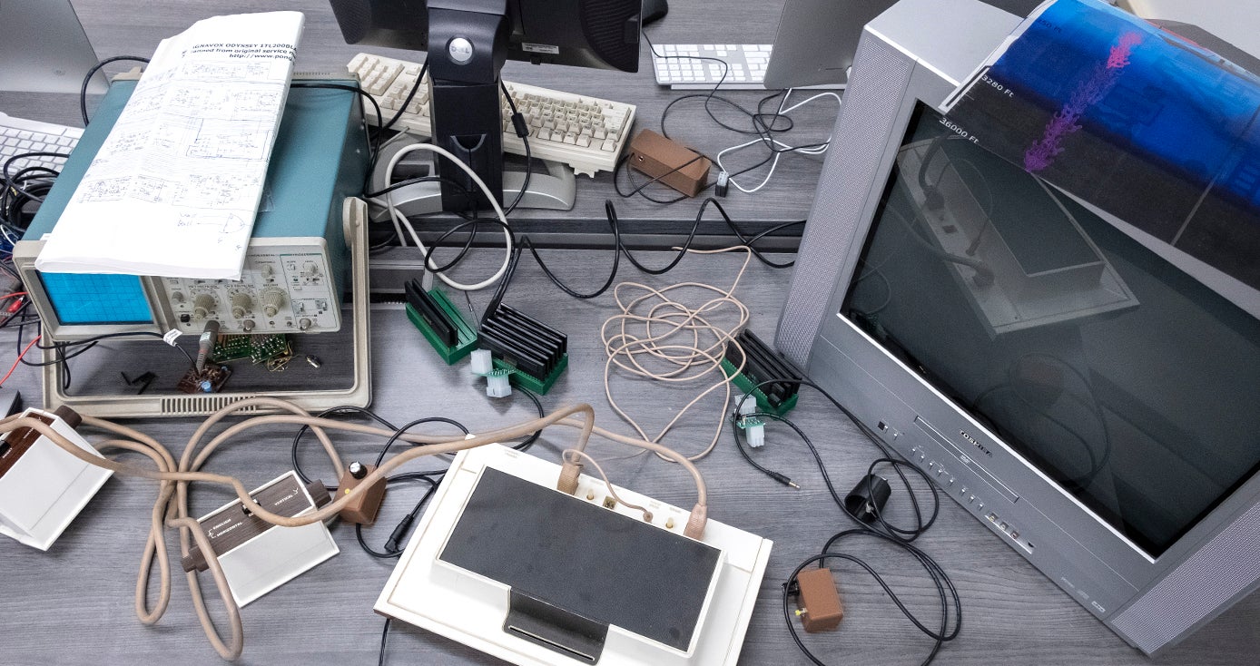 a tabletop filled with wires, a TV, an Odyssey and other equipment