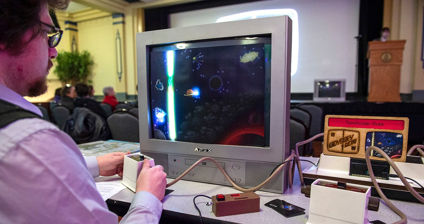 Student at a computer monitor, which shows graphics of an outer-space game