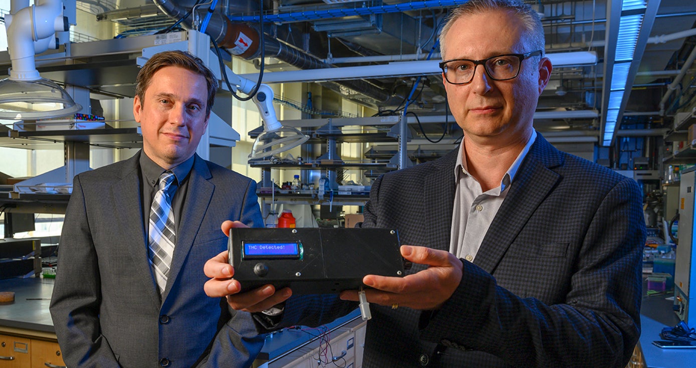 Associate professor of electrical and computer engineering Ervin Sejdic, left, and professor of chemistry Alexander Star show the prototype of the THC Breathalyzer developed using their interdisciplinary research. 