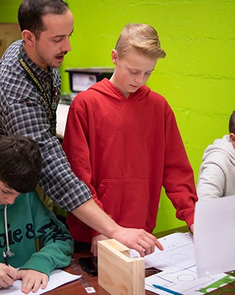 Mannarino and a student in a red hoodie looking at documents on a table