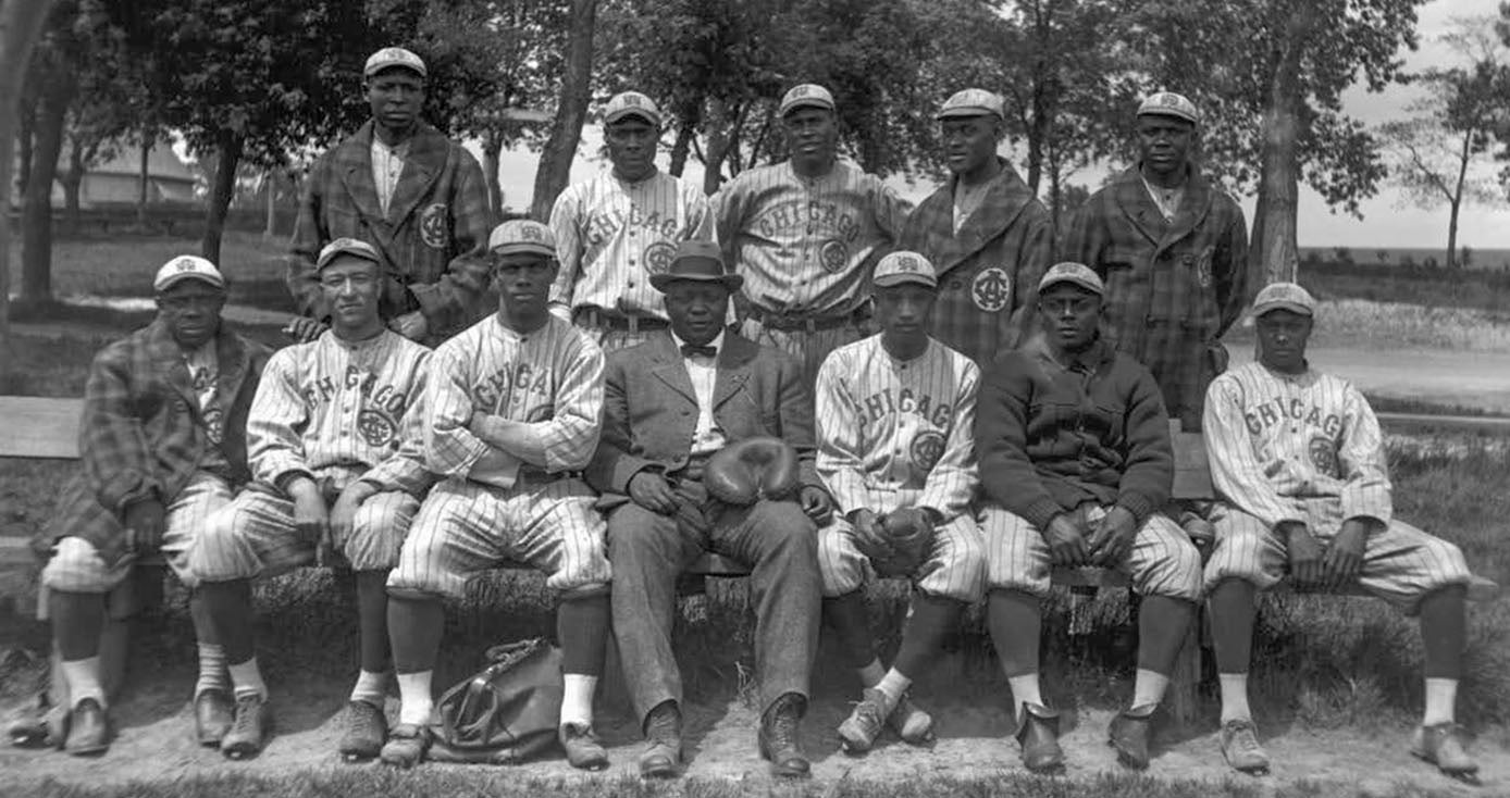 Members of the Chicago American Giants pose for a team portrait in 1914. Rube Foster is seated in the center of the first row wearing a suit.