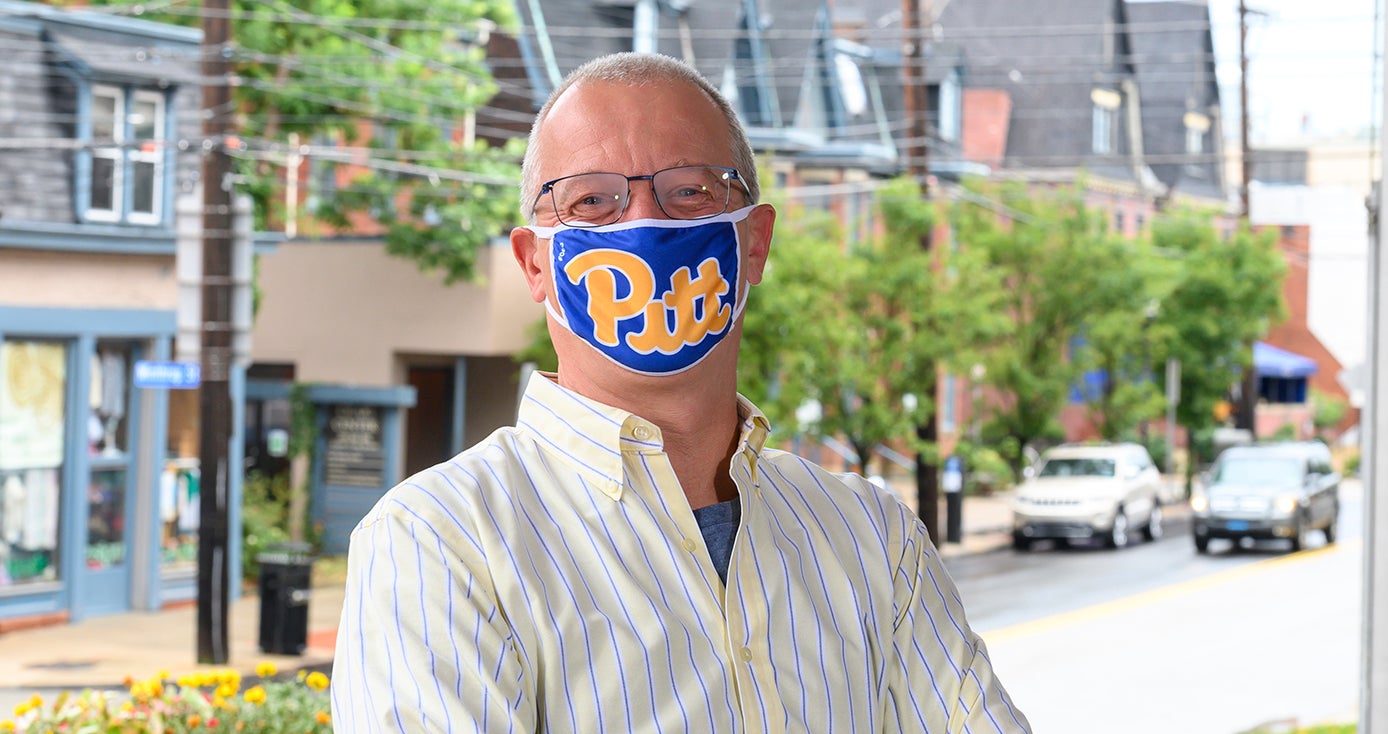 A man in a Pitt face mask and striped shirt