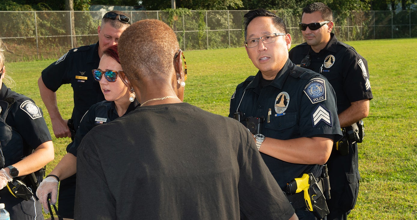 A Pitt police officer talks to members of the Pitt community