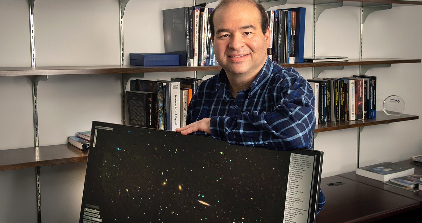 Jeffrey Newman, with a monitor displaying two dimensional stars and galaxies