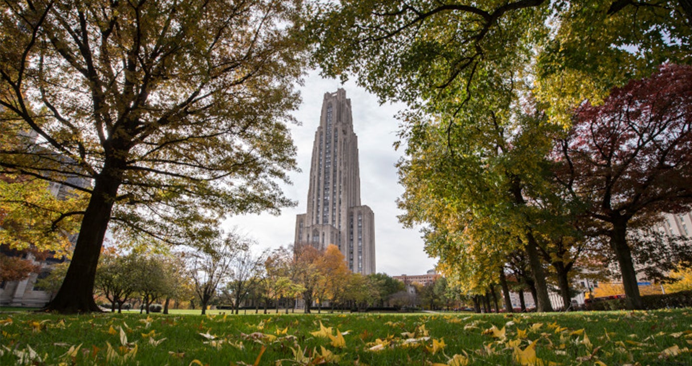 The Cathedral of Learning framed by trees in the fall