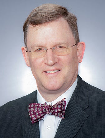 Daniel Hall in a dark suit and red patterned bowtie.