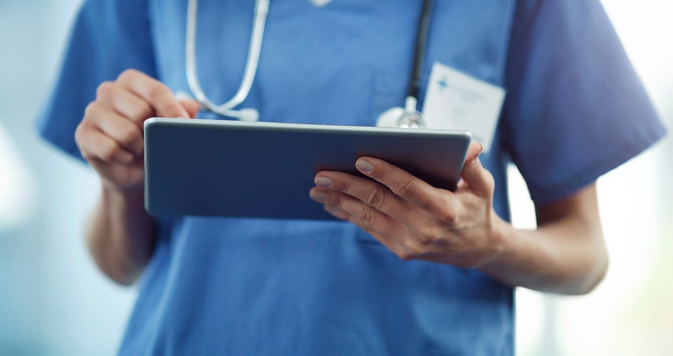 A healthcare professional uses a tablet