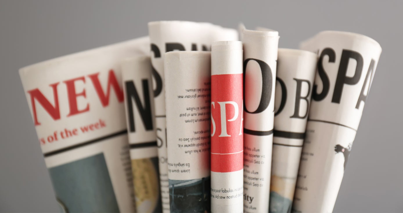 several folded newspapers on a gray background