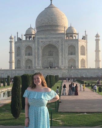 Molly Brandenburg pictured in blue dress with the Taj Mahal in Agra, India, in the background. 
