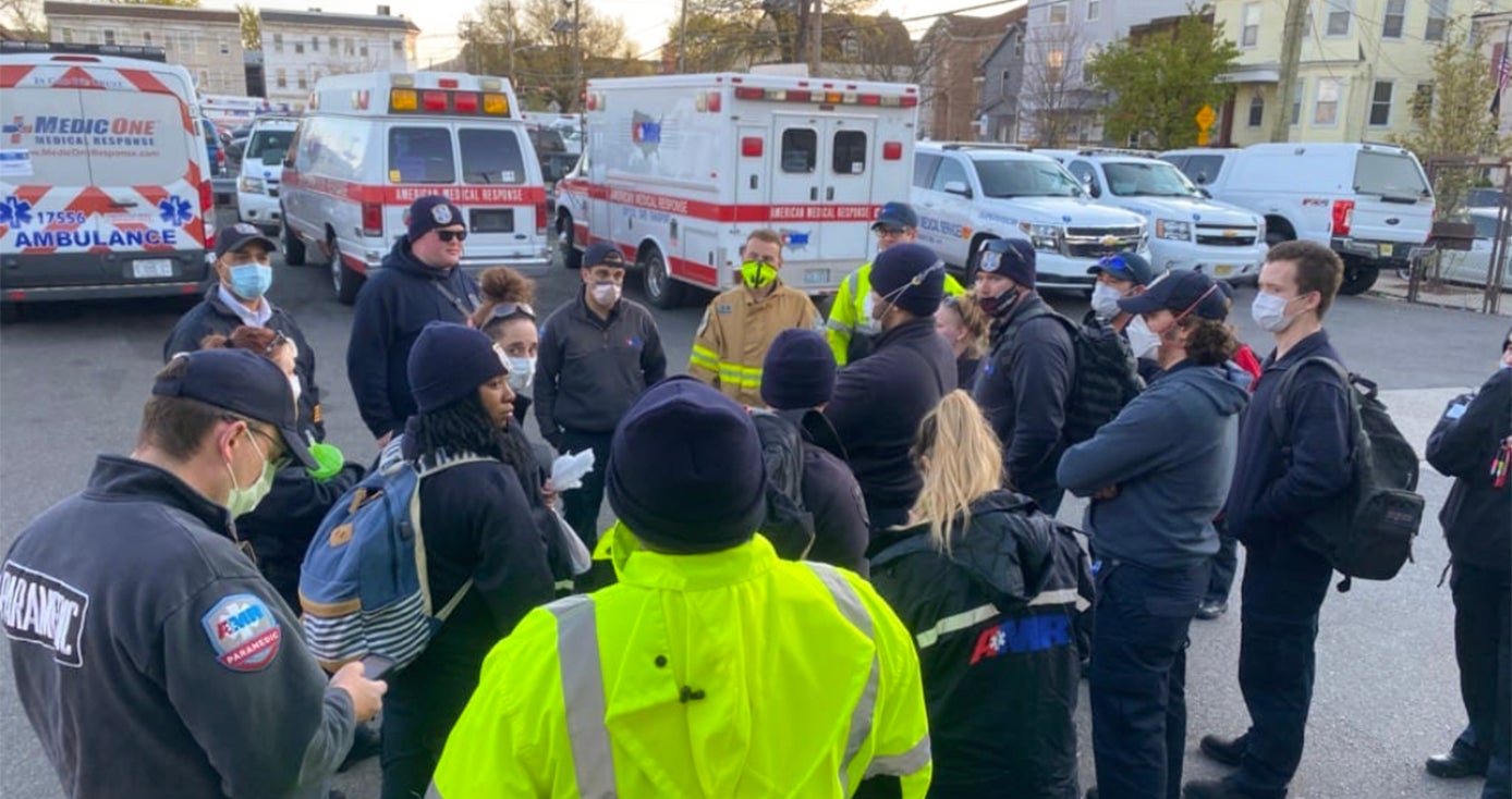 A group of EMTs gathers in a parking lot