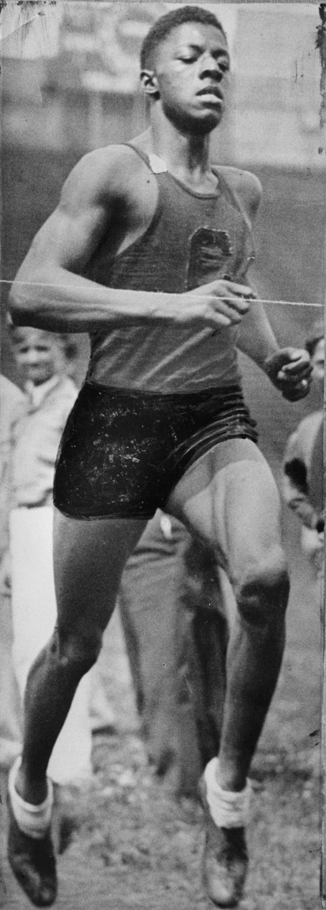 Black and white historical newspaper photo of John Woodruff running in the 800-meter race in the 1936 Olympics in Berlin, Germany