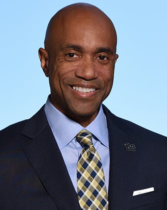 A man in a blue dress shirt and black suit jacket