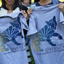 two people holding up gray t-shirts that say Year of Diversity