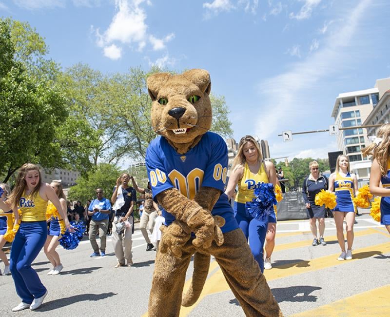Roc the panther dancing among Pitt cheerleaders in the street