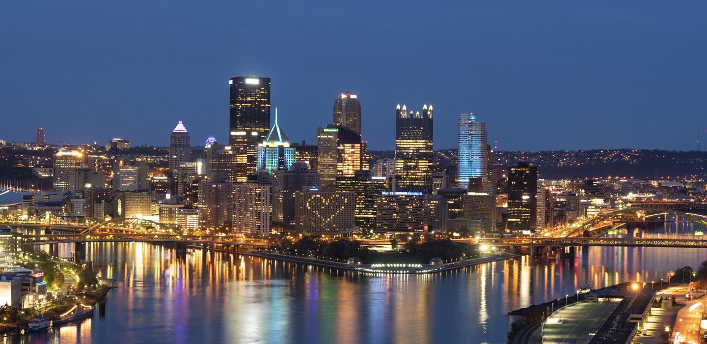 The city of Pittsburgh at night with a heart displayed utilizing a building's windows