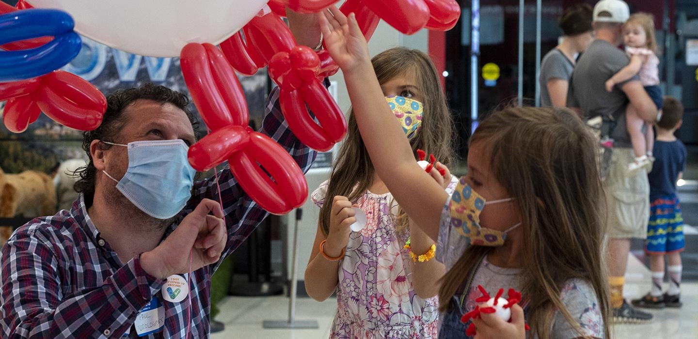 Two children taking part in balloon demonstration 