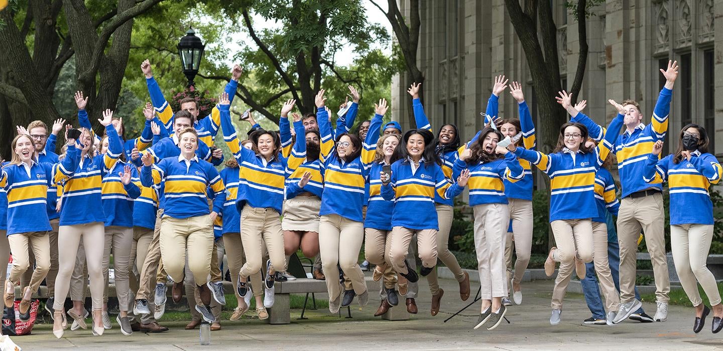 Students in blue and gold jumping together