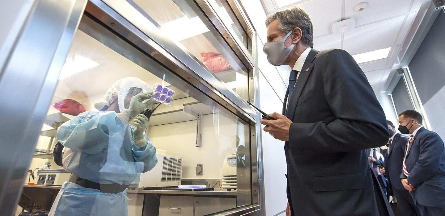 Antony Blinken wearing face mask and suit visiting lab 