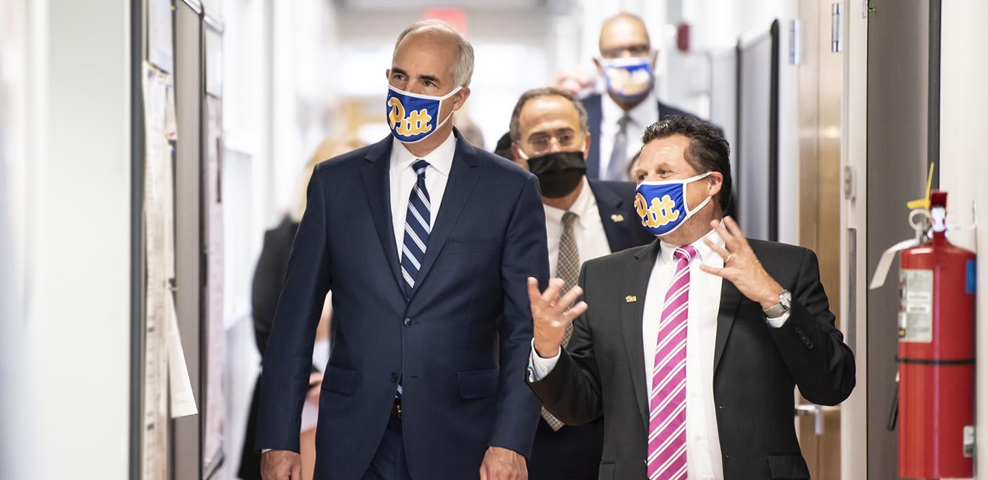 Bob Casey and Paul Duprex walking and talking with face masks