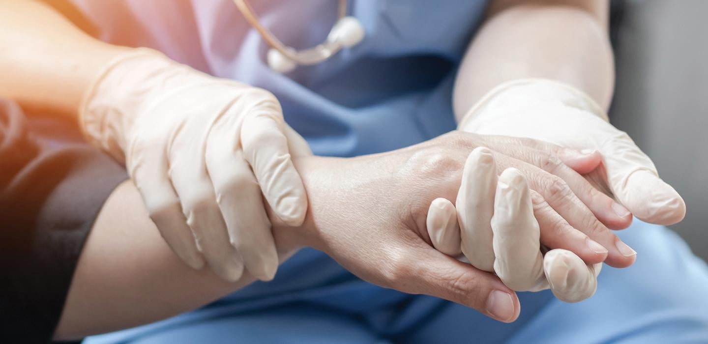 Nurse holding the hand of a patient