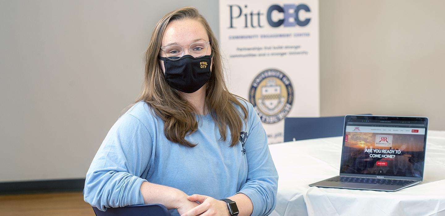 Julia Donnelly sitting in front of laptop with Pitt CEC banner in background