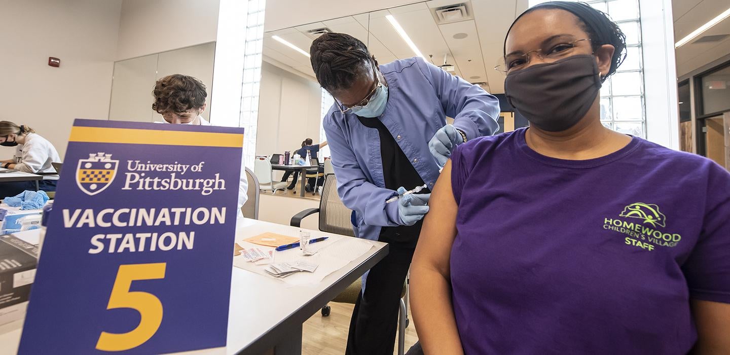 Woman in purple shirt getting a vaccine at a clinic in Homewood