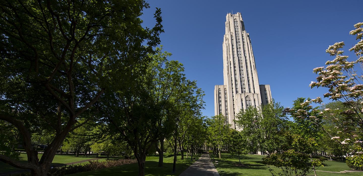 Cathedral of Learning behind trees on a sunny day