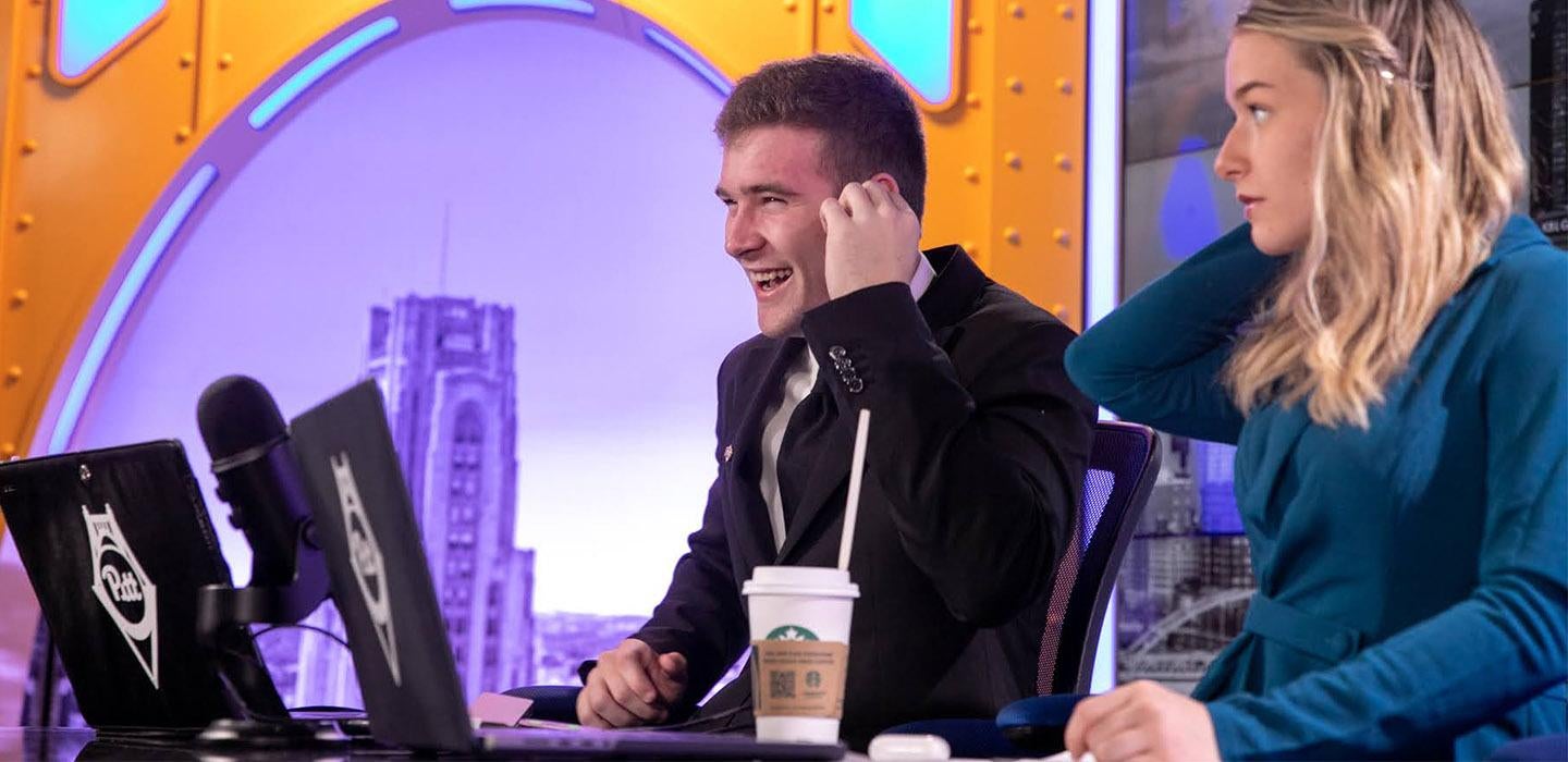 two hosts at a desk in Pitt Studios