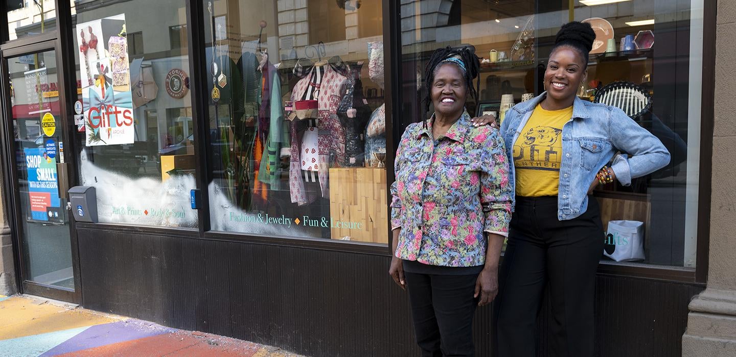 Christine and Brigette Bethea standing in front of store windows