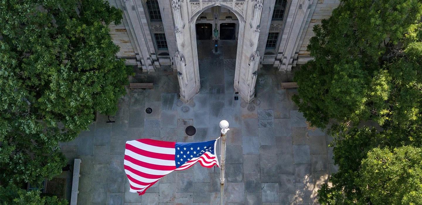 Trees surrounding an American flag shown from above 