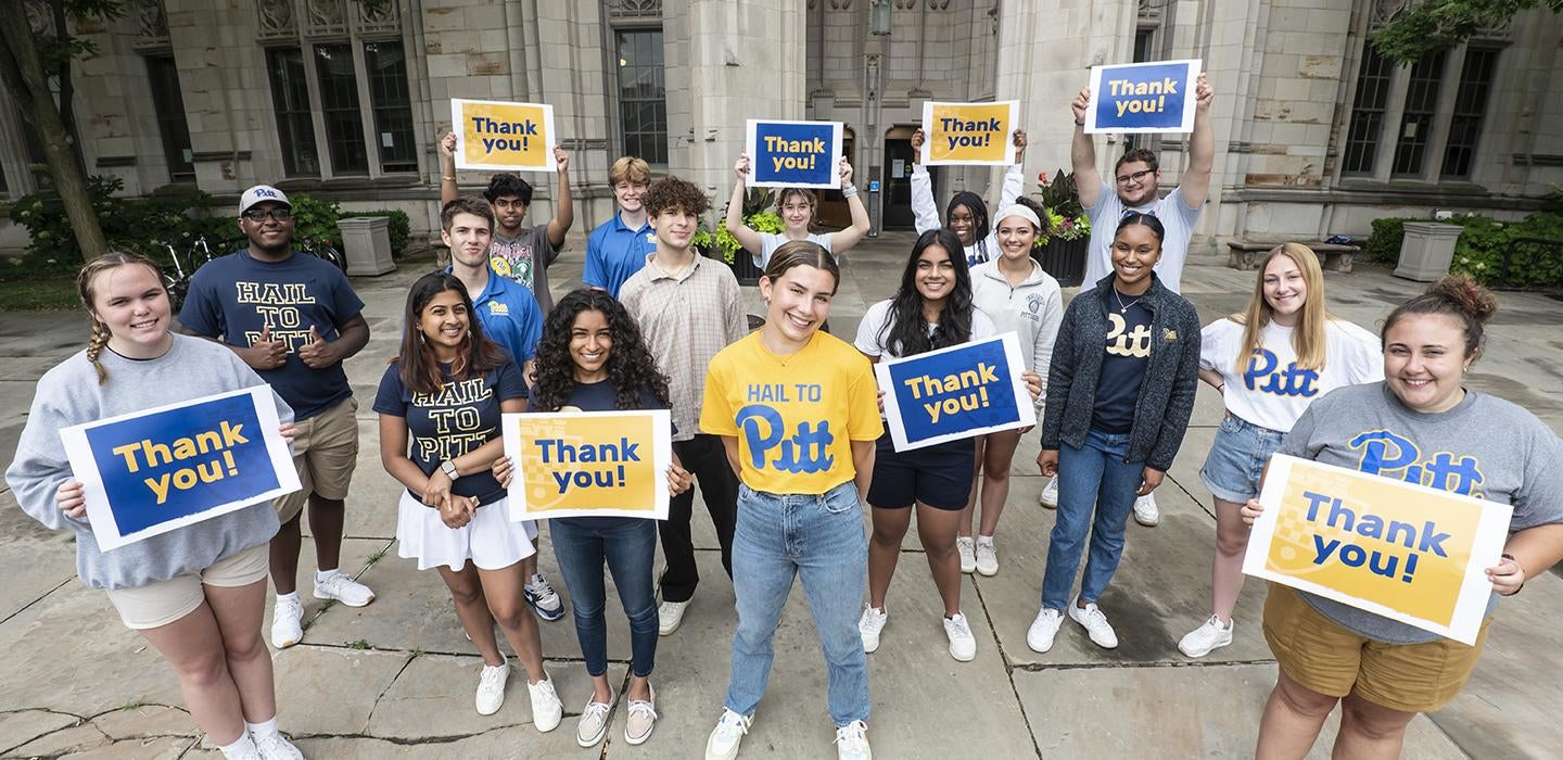 a group of students outside the Cathedral holding "thank you" signs