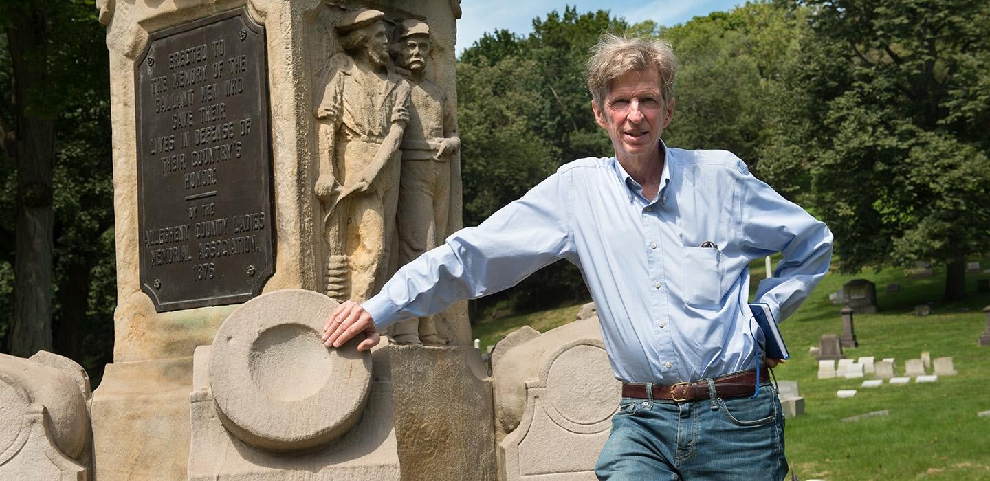 Kirk Savage leans on a monument