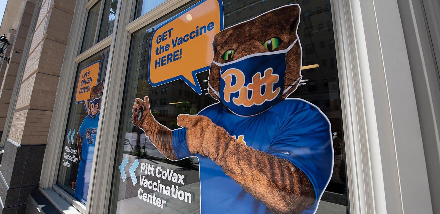 A decal of Roc wearing a mask with a voice bubble that says Get the vaccine here