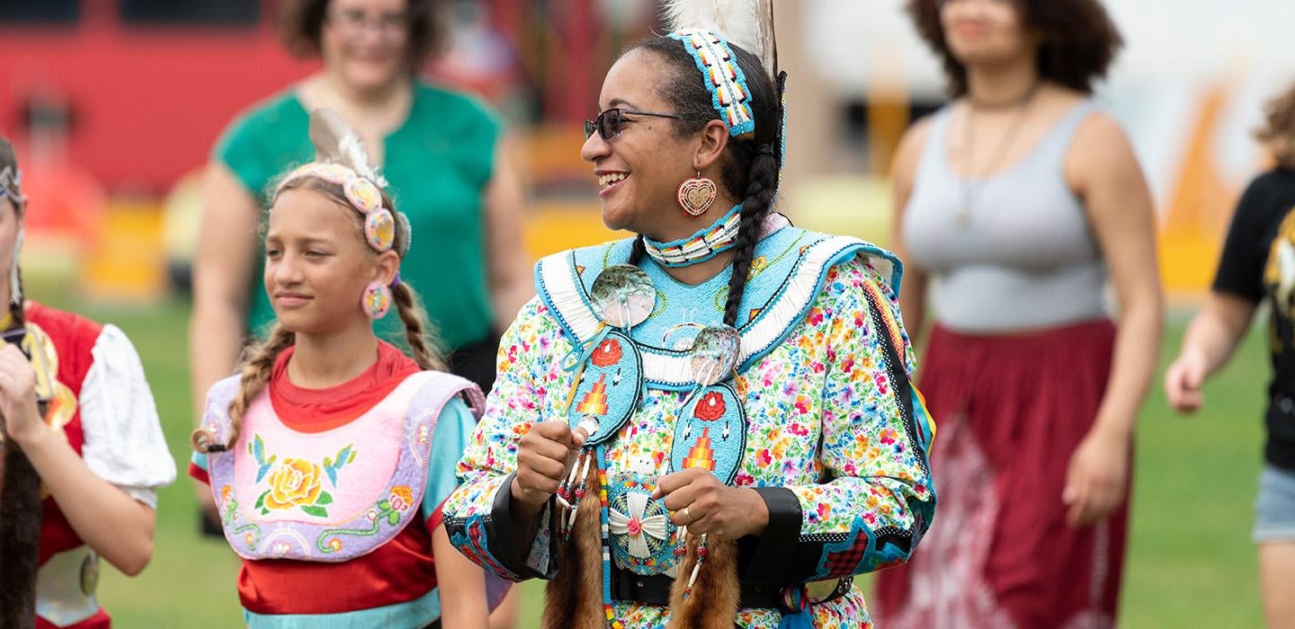An indigenous person in traditional attire at a powwow
