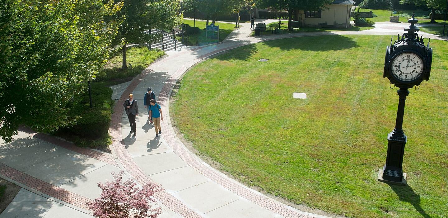 A drone shot of people walking by a lawn on Pitt-Titusville's campus