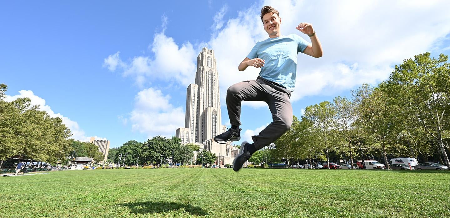 Lafferty jumps on the lawn in front of the Cathedral of Learning