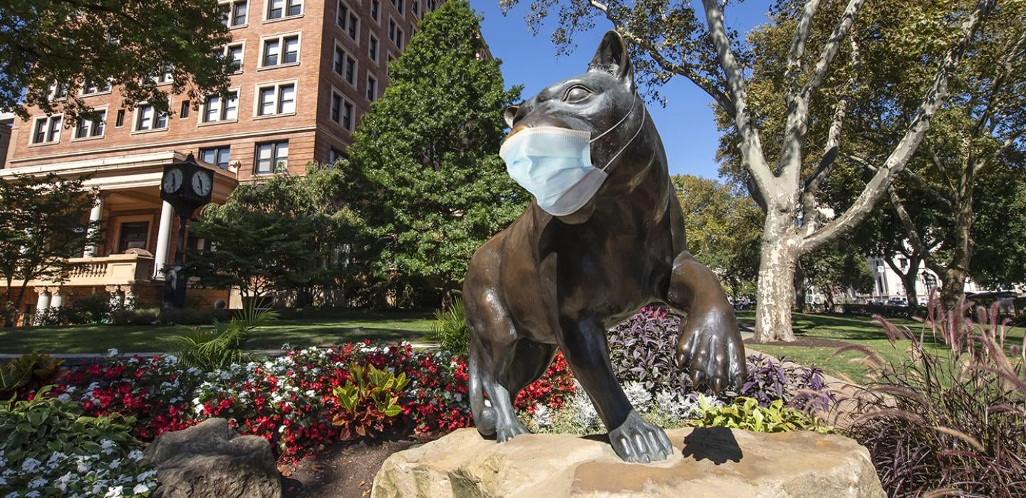 A panther statue with a face mask on