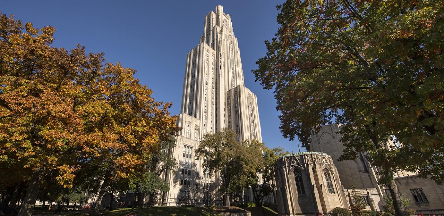 The Cathedral of Learning framed by trees in the fall
