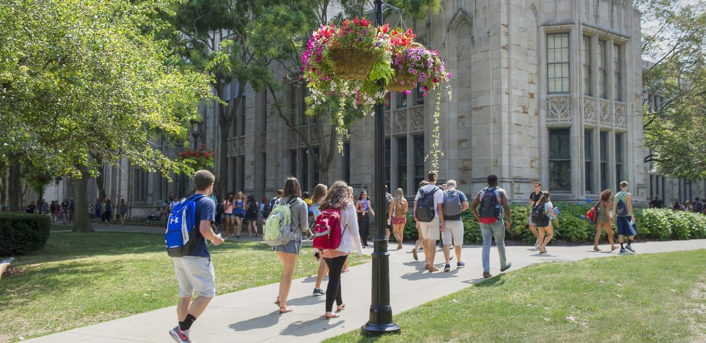 students walking on a sidewalk in front of the Cathedral