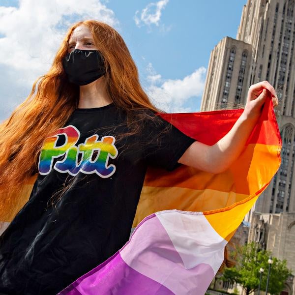 photo of a Pitt student with a Pride flag
