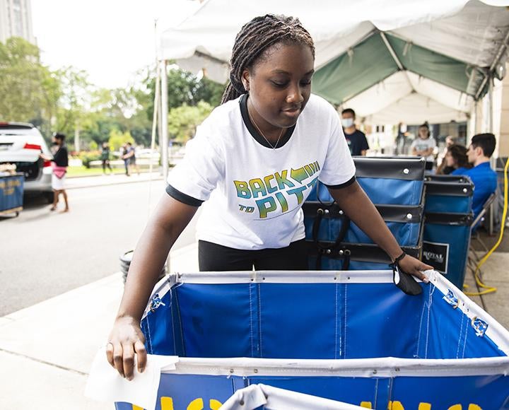 Pitt student passing out blue moving carts 