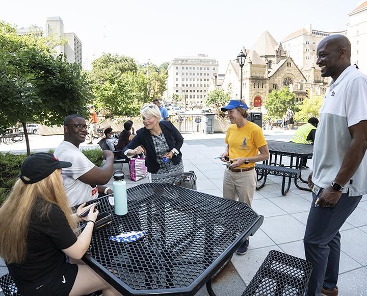 Pitt faculty greeting students at tables outside