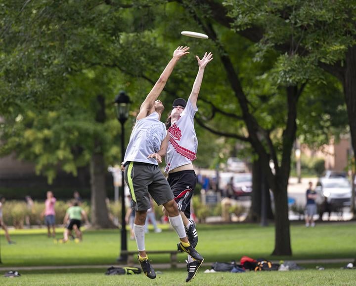 Two students catching a frisbee