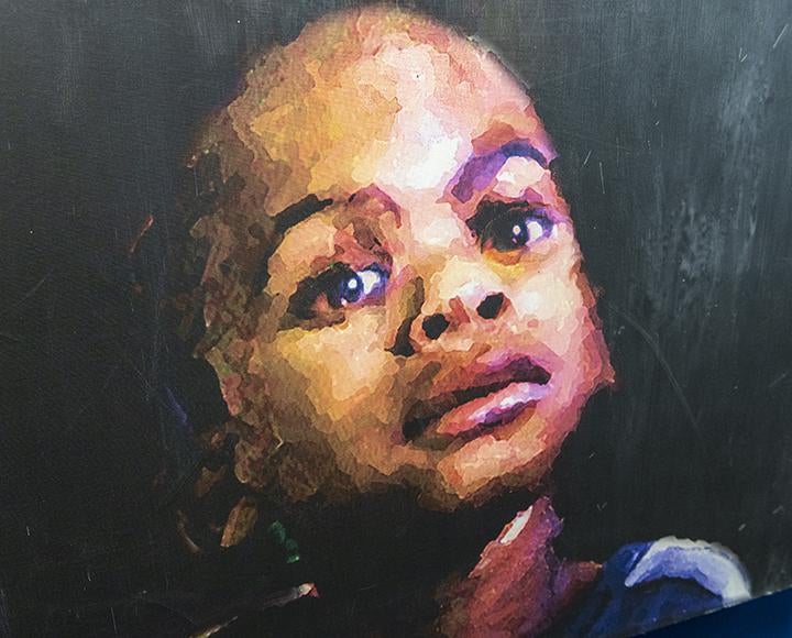 Painting of child's face, dark background