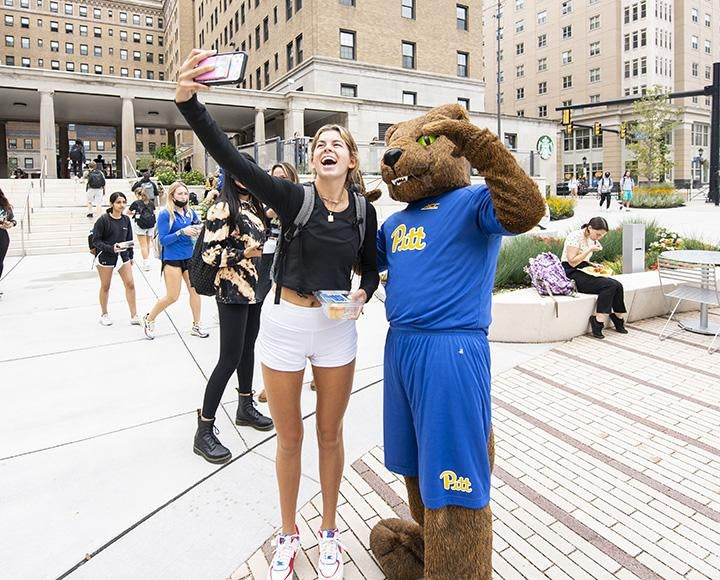 Emma Logan taking selfie with panther mascot during I Love Pitt Day.